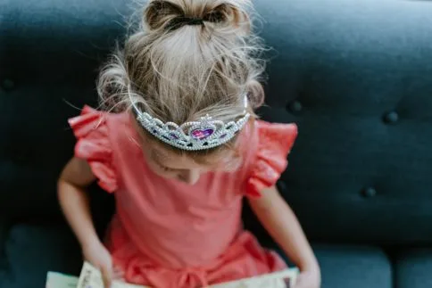 girl wearing crown for preschool devotion about God being king