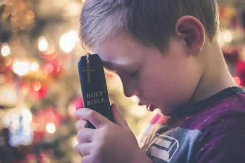 Child holding Bible God wants us to pray without ceasing